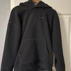Svart fleece hoodie från Levi's - Mysig svart fleece hoodie från Levi's med en stor ficka framtill och en bekväm huva. Perfekt för kyliga dagar när du vill hålla dig varm och stilren. 🖤