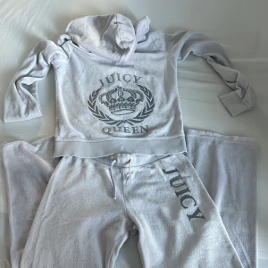 Vintage Tracksuit från Juicy Couture - Säljer en vit hoodie och matchande byxor från Juicy Couture då settet tyvärr blivit för litet. Storleken säger xl men är mer en xxs-xs i vuxen storlek. Hoodien har dragkedja med glittrigt juicy Queen märke och en glittrig Juicy-logga på bootcutbyxorna. Perfekt för en avslappnad stil med en touch av glamour. 🖤