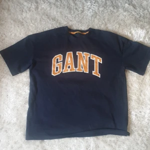 Tröjor 150kr st - Säljer svarta hoodies från Gant med en broderad logga och ett emblem på bröstet. Tröjan har en klassisk känguruficka och en bekväm huva. Perfekt för en avslappnad stil. 