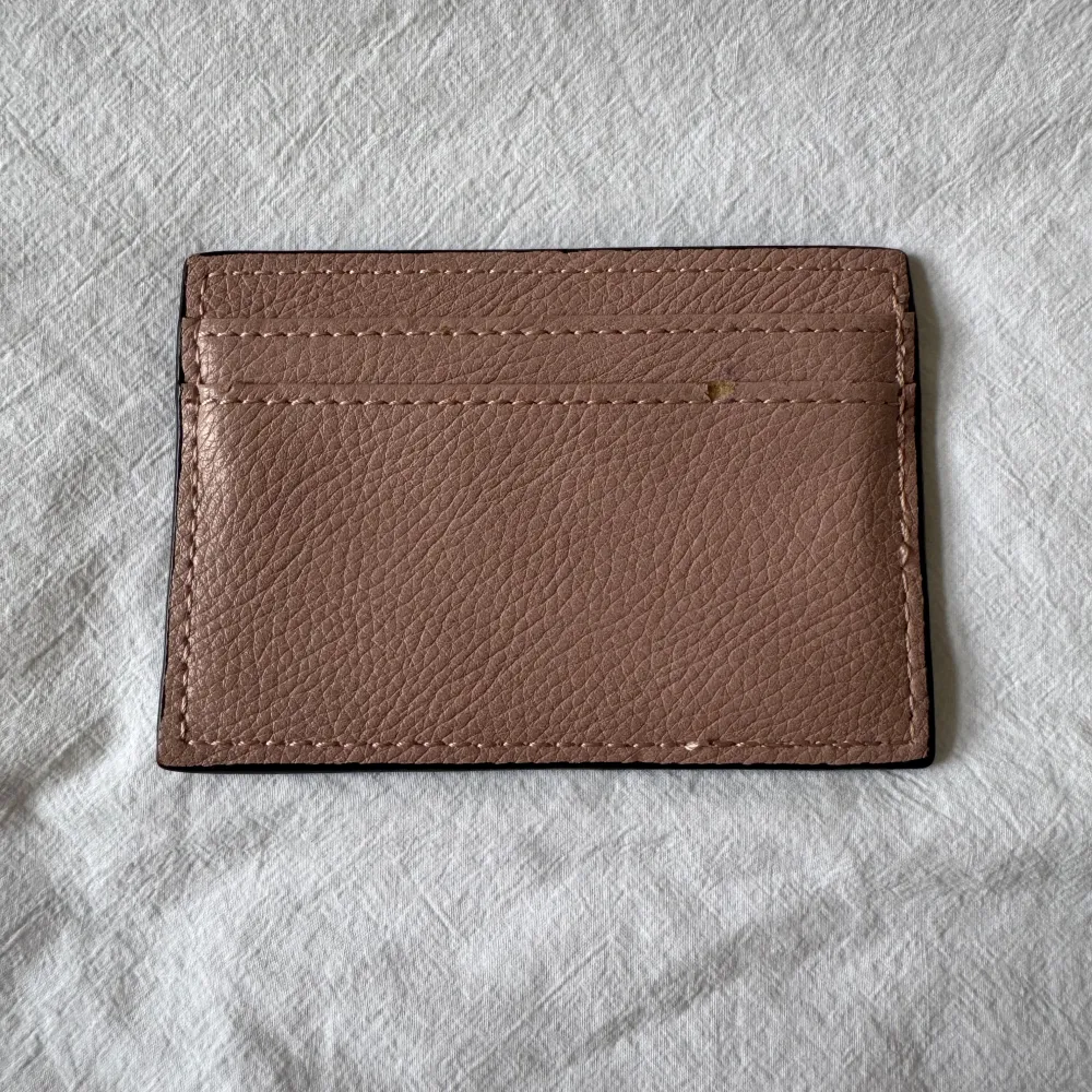 Stilrent beige/rosa kortfodral från Don Donna. Har en mindre defekt på baksidan, se blid 2. Asusteet.