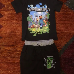 Svart Minecraft t-shirt med short finns i alla storlekar - Säljer en svart t-shirt med Minecraft-tryck. Perfekt för alla Minecraft-fans! 