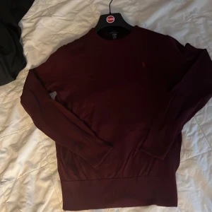 Vinröd tröja från Ralph Lauren - Säljer en vinröd tröja från Ralph Lauren. Tröjan har inga slitningar. Perfekt för lite finare stil men även för en vanlig vardag. 