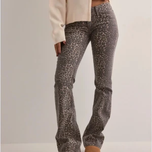 Leopardmönstrade byxor - Snygga leopardmönstrade byxor med bootcut-stil. Perfekta för att ge din outfit en trendig touch. Byxorna har en low waist midja och är tillverkade i ett bekvämt material som ger en skön passform. Dom är köpta på Nelly. De har bara legat i min gaderob dom inte passar mig. Därför vill jag ge någon annnan möjlighet till att använda dom.