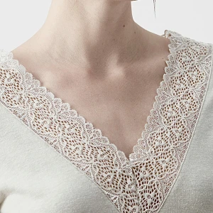 Vit t-shirt med spetsdetaljer - Vit t-shirt med v-ringning och vackra spetsdetaljer längs halsringningen. Perfekt för en stilren och romantisk look. Matchar med allt😍