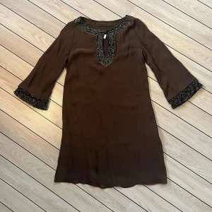 Fendi vintage klänning  - En vintage från Fendi.  Har en liten missfärgning längst ner i kanten på baksidan. Syns väldigt lite. Längden på klänningen är 90cm och armlängden från armhålan är 34 cm. Det är två tunna lager. Vet ej materialet. 