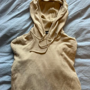 Beige hoodie från J.Lindeberg - Säljer en stilren beige hoodie från J.Lindeberg. Tröjan har en klassisk design med huva. 