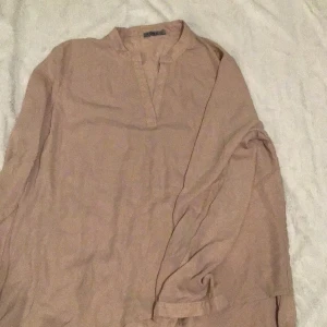 Beige blus från Icona - Säljer en stilren beige blus från Icona i storlek XL. Blusen är tillverkad i 100% polyester och har en enkel design med långa ärmar och en diskret krage. Perfekt för en avslappnad men elegant look.