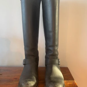 Primeboots stövlar svarta 36 - Snygga svarta stövlar från Primeboots i skinn med dragkedja baktill och dekorativa spännen. Perfekta för höst och vinter, dessa stövlar kombinerar stil och funktionalitet. Har även ett brunt par. 