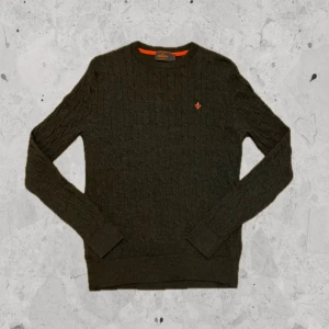 Mörkgrå stickad merino tröja - Morris - Mörkgrå ribbstackad merinoulls tröja från Morris. 100% merinoull.  Storlek: S. Skick: 9,5/10. Nypris: 1500kr. Kontakta oss för fler bilder eller info!