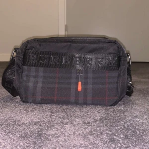 Svart och rutig axelväska från Burberry - Snygg svart axelväska från Burberry, aldrig använd !