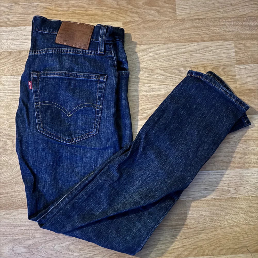 Säljer ett par klassiska Levis 502 jeans i mörkblå denim. De har en normal passform och är tillverkade i slitstarkt jeansmaterial. Perfekta för en avslappnad stil med en snygg finish.. Farkut & Housut.