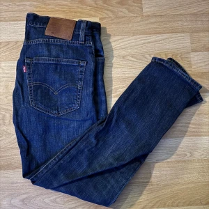 Levis 502 jeans i mörkblå denim - Säljer ett par klassiska Levis 502 jeans i mörkblå denim. De har en normal passform och är tillverkade i slitstarkt jeansmaterial. Perfekta för en avslappnad stil med en snygg finish.