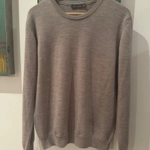 Grå tröja från Oscar Jacobson - Säljer en stilren beige tröja från Oscar Jacobson. Nypris 1400-: Tröjan är långärmad och har en klassisk rund halsringning. Perfekt för en elegant och avslappnad look.