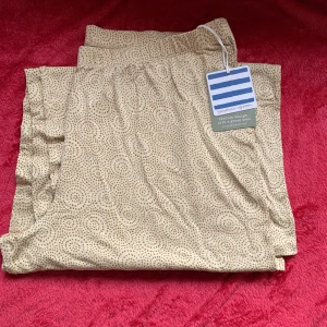 Två pack vida byxor från Gudrun Sjödén  - Säljer ett par bekväma beige byxor med ett diskret prickigt mönster. Perfekta för en avslappnad stil. Byxorna har en elastisk midja för extra komfort.