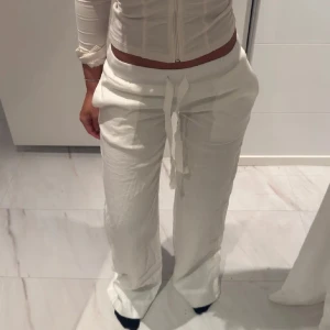 Vita linnebyxor med knytband - ⚠️KAN BYTAS MOT M ELLER S⚠️ Snygga och bekväma vita linnebyxor med knytband i midjan. Perfekta för en avslappnad stil. Byxorna har en loose passform och är tillverkade i ett lätt och luftigt material.