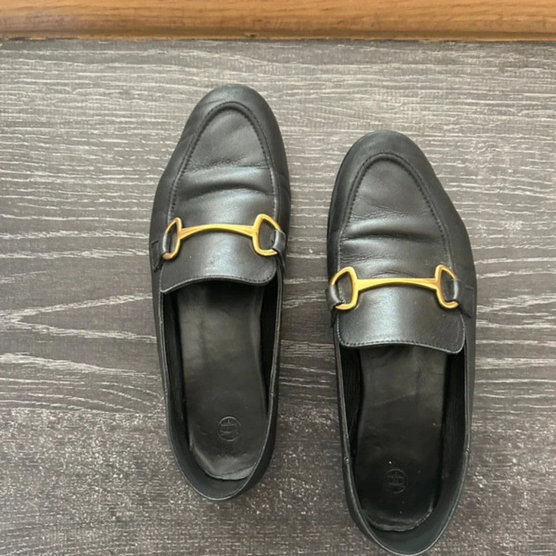 Svarta loafers med gulddetaljer