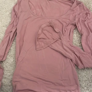 Rosa långärmad topp - Säljer en söt rosa långärmad topp med rund halsringning och slits på båda armarna. Perfekt att matcha med jeans. Toppen har en mjuk och bekväm passform.