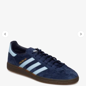 Adidas Originals Pelias sneakers - Snygga Adidas Originals sneakers i mörkblå mocka med ljusblå ränder och detaljer. Skorna har en klassisk design med snörning och en brun sula