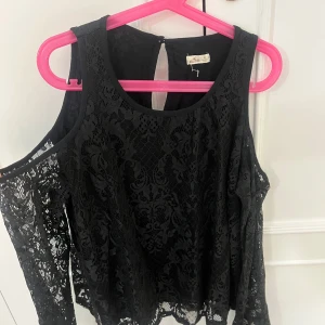 Svart spetsblus från Hollister - Snygg svart spetsblus från Hollister med offshoulder-design. Aldrig använd🤩