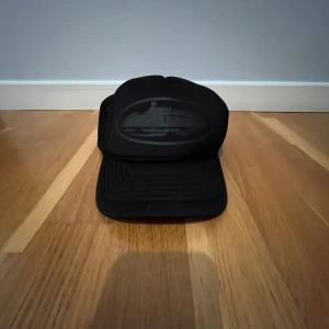 Svart keps med meshdetaljer - Snygg svart keps med meshdetaljer och justerbar passform. Perfekt för en avslappnad stil.