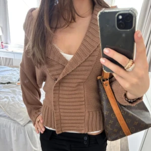 Brun stickad offshoulder kofta - Säljer en snygg brun stickad kofta. Lånad bild då jag köpte den på plick. Koftan är använd en gång.