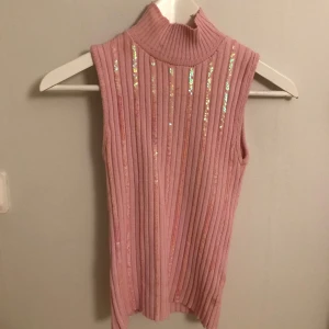 Vintage linne - Snygg rosa ribbad polotopp med glittriga detaljer. Den är ärmlös och perfekt för en trendig look. Passar bra till både jeans och kjol. Köpte vintage så väldigt unik