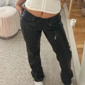 Lågmidjade Skinnbyxor - Säljer ett par svarta byxor i skinnimitation. De har en lågmidjad passform och en straight stil. Perfekta för en cool och edgy look. Byxorna har fickor både fram och bak, och stängs med dragkedja och knapp. Passar perfekt till både vardag och fest! köpta nya för 400 men säljer för 300!❤️