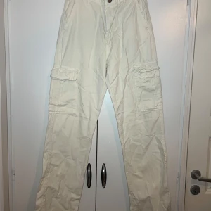 Beige cargobyxor - Säljer ett par beige cargobyxor från Stradivarius. Byxorna har flera praktiska fickor och en knappstängning framtill. Perfekta för en avslappnad stil.
