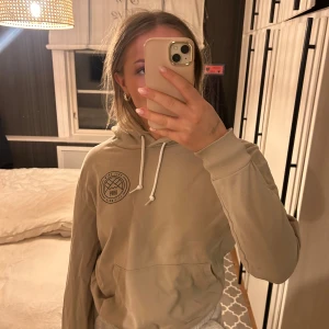 Beige hoodie från Dope - Säljer en beige hoodie med tryck på bröstet och ryggen. Nyskick. Strl 40