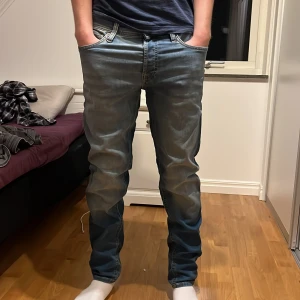 Slim fit jeans - Säljer ett par snygga blå jeans i bra skick. W32 L 34.De har en klassisk straight passform och är midwaist.Jeansen har en cool tvättad look och knappar istället för dragkedja. Perfekta för både vardag och fest!