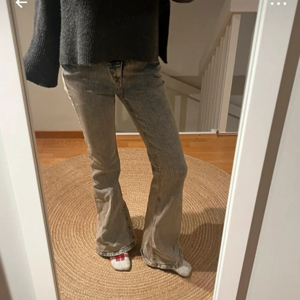 Säljer ett par grå bootcut jeans i bra skick. De är lågmidjade och har en klassisk femficksdesign. Perfekta för en avslappnad stil och passar till både vardag och fest. Sköna och trendiga!. Farkut & Housut.