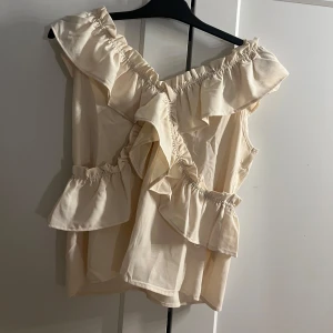 Beige volangtopp - Oandvänd beige topp med volanger och offshoulder-design. Perfekt för en fest.💕💕🌟🌟159KR.🫶🏼🫶🏼
