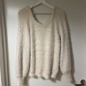 Vit fluffig tröja från Bik Bok - Mysig vit fluffig tröja från Bik Bok i storlek S. Tröjan har en v-ringad design och långa ärmar.