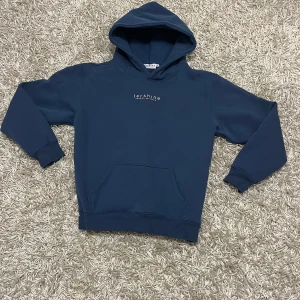 Mörkblå hoodie från Tershine - Säljer en snygg mörkblå hoodie från Tershine med en klassisk design. Den har en praktisk magficka och en bekväm huva. Perfekt för en avslappnad stil.