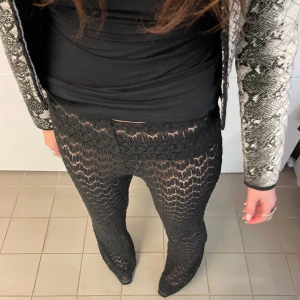 SVARTA SPETSBYXOR  - Svarta spetsbyxor i tjockt spetsmaterial. Riktigt fina, lågmidjade och bootcut, och långa så perfekt för långa tjejer! Tjejen på bilden är 175 cm lång! Hör av er för mått och vid frågor!! I nyskick