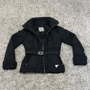 Moncler jacka - Säljer en snygg svart dunjacka från Moncler i mycket bra skick. Jackan har en dragkedja framtill och ett bälte i midjan för en figursydd look. Perfekt för kyliga höst- och vinterdagar. Den har långa ärmar och praktiska fickor med dragkedja. Passar både till vardags och lite finare tillfällen.