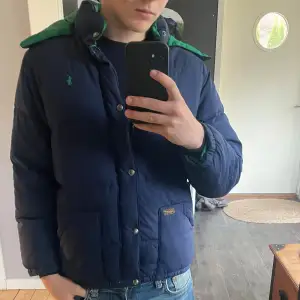 Säljer en snygg blå dunjacka från Polo Ralph Lauren. Jackan har långa ärmar och knappar framtill. Perfekt för kalla dagar och håller dig varm och stilren. Passar bra till både vardag och lite finare tillfällen. 🧥💙storlek L ungdom passar xs