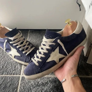 Golden Goose i marinblå - Snygga blå golden goose, strl 41 men sitter mer som 42. Skorna är i bra skick, men små defekter kan förekommer.  Box medföljer 