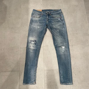 Dondup george jeans - Tja sälja nu mina riktigt feta dondup ”george” jeans med snygga slitningar! Varsamt använda, finns en pytteliten defekt inne i jeansen, kan skicka bild på det, men absolut inget som syns eller nån big deal! Nypris på dessa jeans ligger på 3500kr! Bara att fråga vid eventuella funderingar mvh 