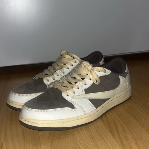 Nike Air Jordans i beige och brun - Säljer ett par Nike Air Jordans i beige och brun med snörning. Skorna har en unik design med röda detaljer på hälen och texten 'Cactus' på innersulan. Perfekta för sneaker-entusiaster!