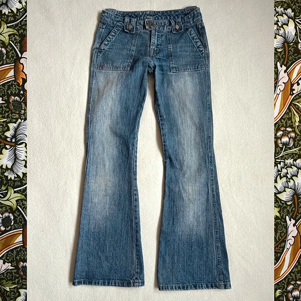 Säljer ett par vintage ljusblå jeans i 100% bomull. De har en klassisk bootcut-stil med låg midja och knappar på bakfickorna. Midja ca 35,5cm. Jag har fler bilder och alla mått, bara skriv till mig så skickar jag🌼 Knappen är lite lite lös men inget som påverkar utseendet eller användningen. . Jeans & Byxor.