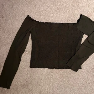 Grön ribbad offshoulder topp från Hollister - Säljer en snygg grön ribbad offshoulder topp från Hollister i storlek L. Toppen har långa ärmar och en tight passform