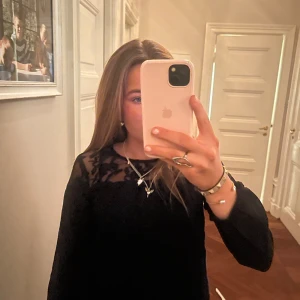 Svart långärmad topp med spetsdetaljer - Snygg svart topp med långa ärmar och eleganta spetsdetaljer vid axlarna. Perfekt för en stilren look.