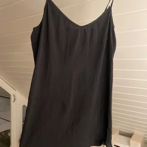Linne  - Svart linne från Vila. Tyvärr en skada bak i ryggen (se bild). Annars fint skick. 