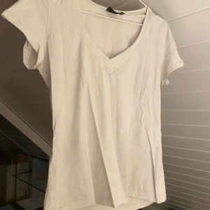 Vit T-shirt  - Vit vringad T-shirt, lite missfärgad men fortfarande i fint skick. 