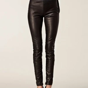 Svarta skinnbyxor från Selected Femme  - Verkligen supersnygga svarta skinnbyxor med tight passform från Selected Femme. Perfekta för en stilren look. Snygga detaljer med dragkedja i benslut! Byxorna är helt nya med lappar kvar! Storlek 38 men upplevs som små i storlek! Nypris 1399 :- 