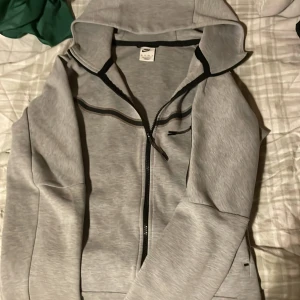 Grå huvtröja från Nike -  Säljer en grå nike Tracksuit I ganska bra skick inga hål men finns lite små tecken på användning. Båda är storlek XS pris kan alltid diskuteras lite vid Snabb affär hör av dig vid frågor