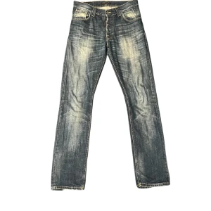 Washed blå Nudie Jeans - Säljer ett par klassiska blå jeans från Nudie Jeans med snygg slitning och wash. Priset kan diskuteras.