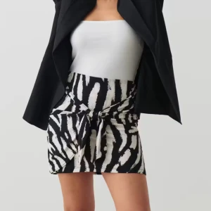 Svartvit kjol med knyt - Trendig svartvit kjol med zebramönster och knyt framtill. Perfekt för att ge din outfit en djärv touch. Kjolen har en kort längd och en tight passform som framhäver figuren. Aldrig använd