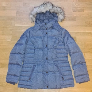 Blå dunjacka från Esprit - Mycket fräsch dunjacka från Esprit. Man kan ta bort både luva och pälsdetalj på luvan. Justerbar i midjan.